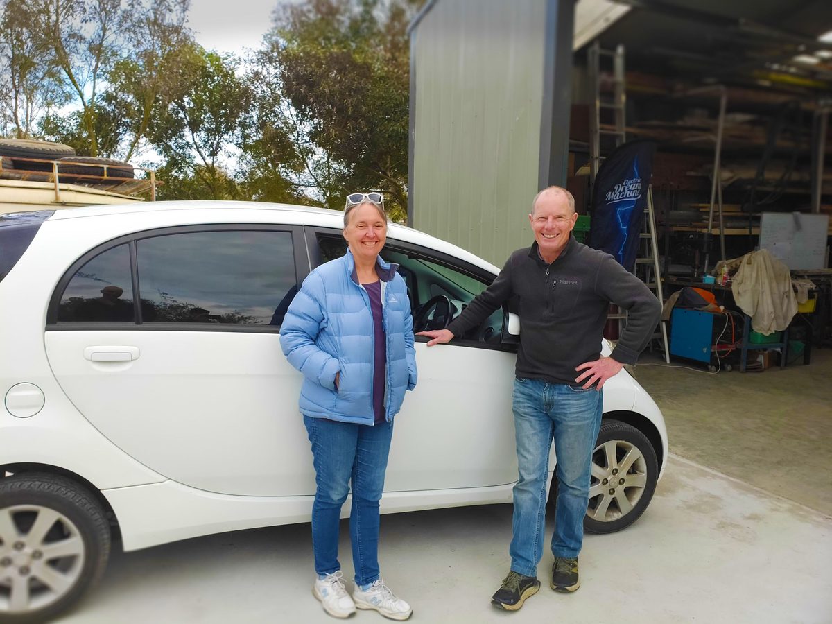 Fiona and Richard Blinco standing beside their electric car