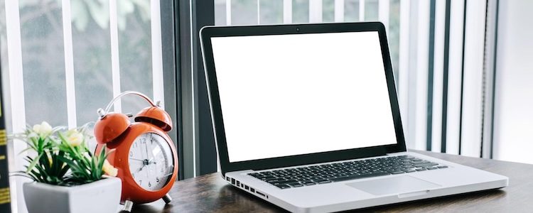 Laptop and alarm clock on a desk